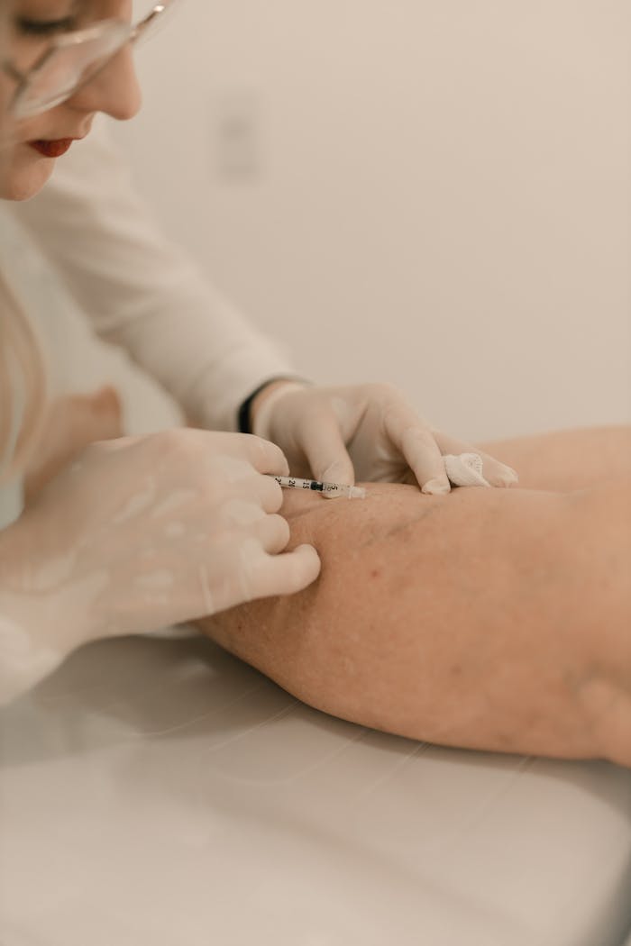 Medical professional administering an injection during a clinical procedure.